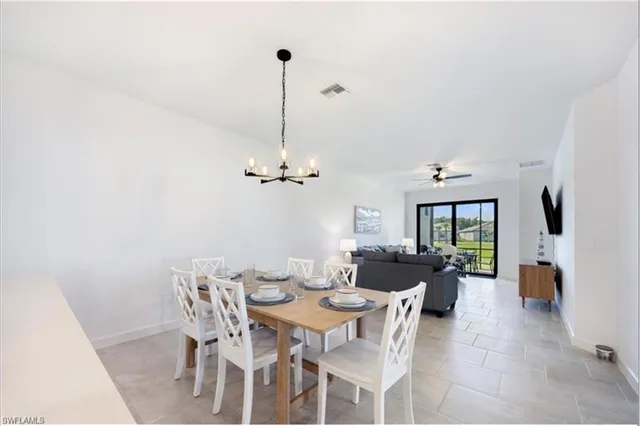 a view of a dining room and livingroom with furniture wooden floor a chandelier