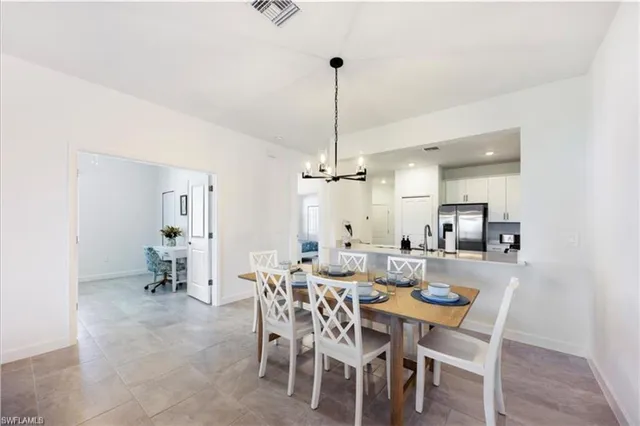 a view of a dining room with furniture a chandelier and wooden floor