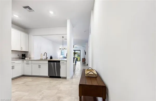 a kitchen with white cabinets stainless steel appliances and sink