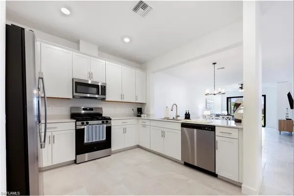 a kitchen with appliances a sink and cabinets