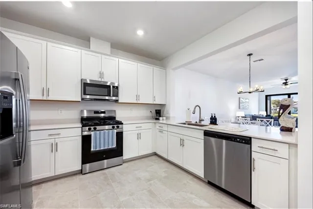 a kitchen with white cabinets and sink