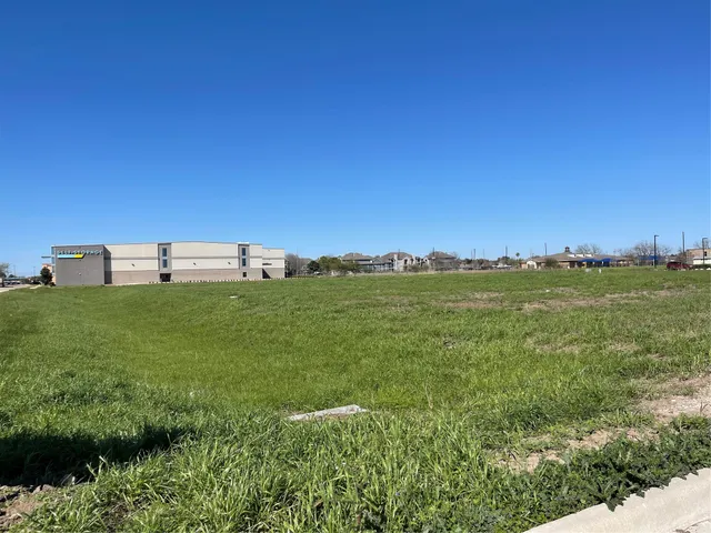 a backyard of a house with lots of green space and a building in the background
