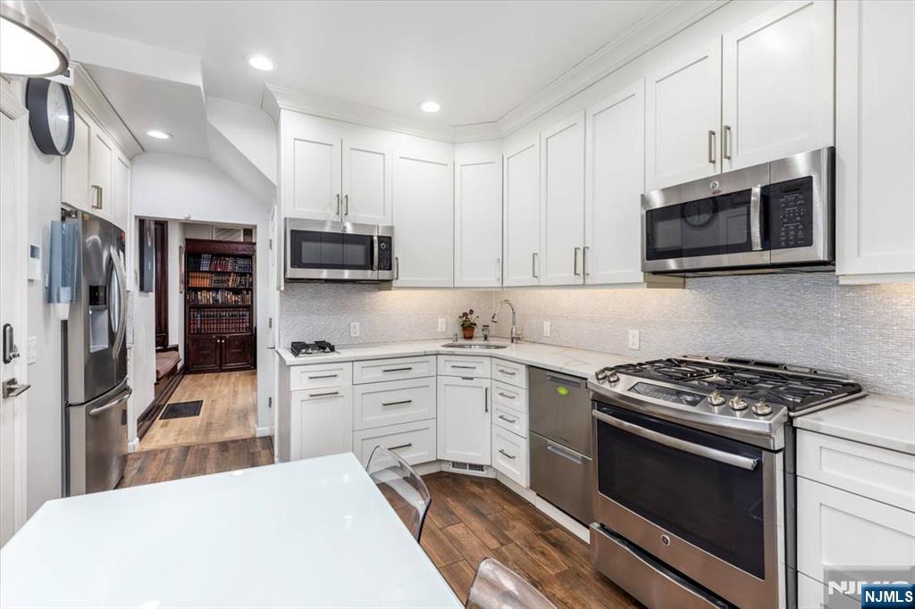 116 Westervelt Place Passaic, NJ 07055 - Photo 12 of 25 a kitchen with stainless steel appliances granite countertop a stove sink microwave and cabinets