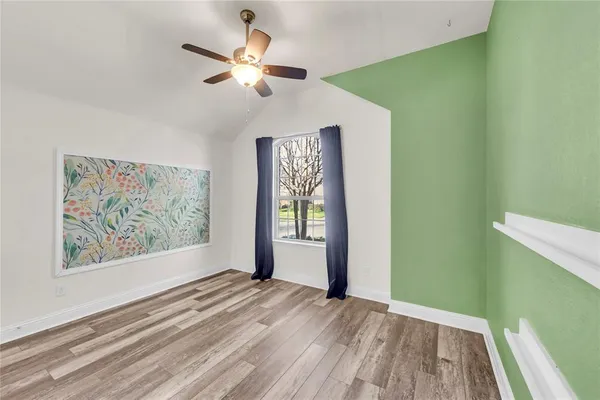 a view of empty room with window and ceiling fan