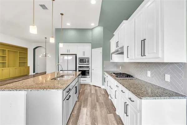 a kitchen with stainless steel appliances granite countertop a stove and a sink