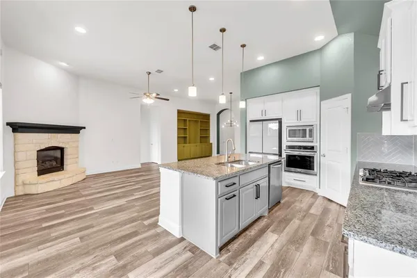a kitchen with stainless steel appliances granite countertop a stove oven and a refrigerator