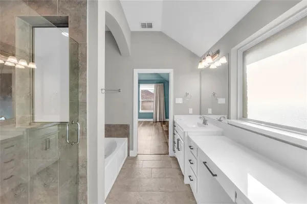 a large white kitchen with a sink and a large mirror