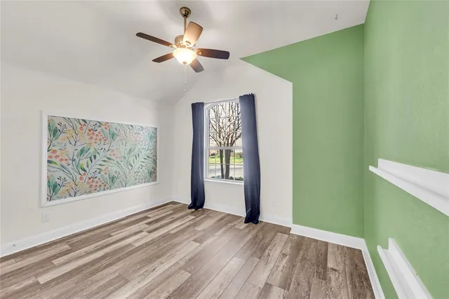 a view of empty room with window and ceiling fan