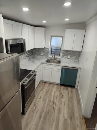 a kitchen with stainless steel appliances granite countertop a stove a sink and a microwave