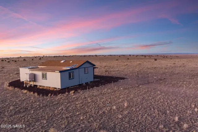 aerial view of a house with a yard and wooden fence
