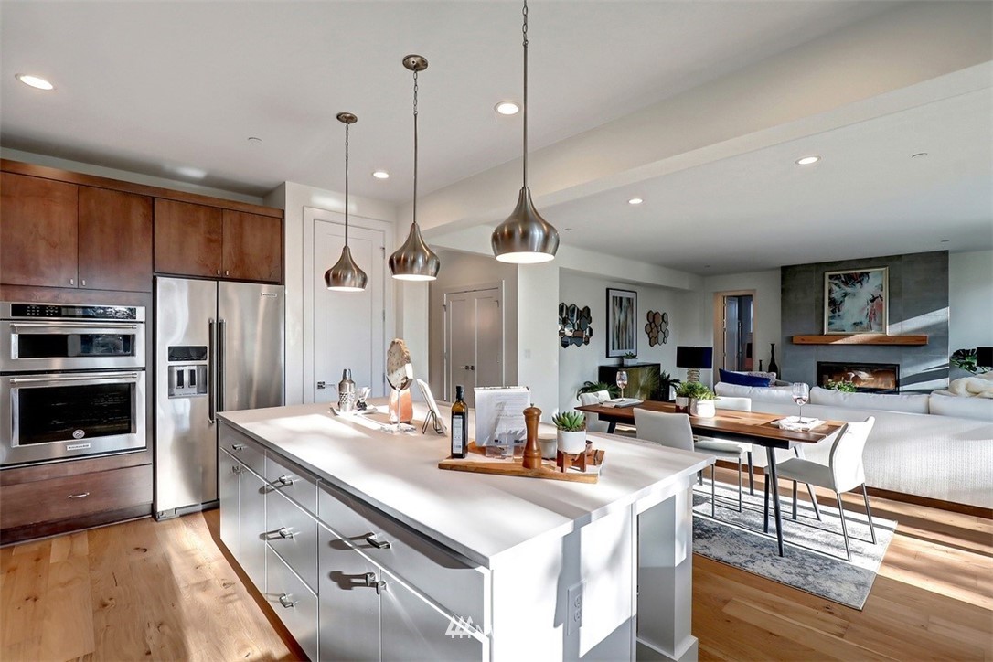 102 232nd Place Southeast, Unit 13 Bothell, WA 98021 - Photo 7 of 26 a kitchen with stainless steel appliances kitchen island granite countertop a stove a sink a oven and a refrigerator with wooden floor