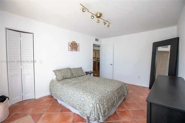 a bedroom with a bed and dresser with mirror