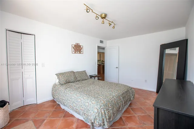 a bedroom with a bed and dresser with mirror