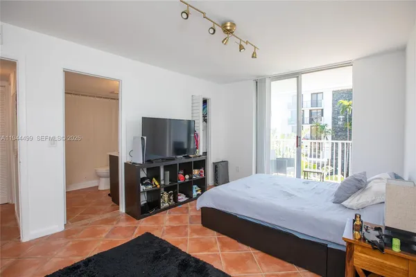 a bedroom with a bed and a flat tv screen on wall