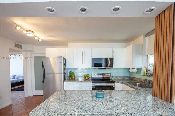 a kitchen with stainless steel appliances granite countertop a refrigerator oven a sink and dishwasher