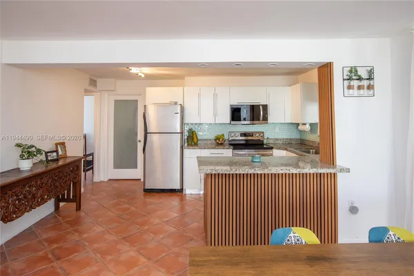 a kitchen with stainless steel appliances granite countertop a refrigerator stove top oven and sink