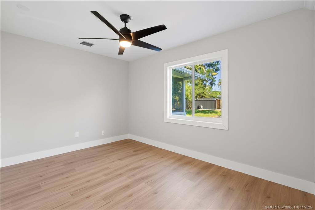 3023 Southeast Banyan Street Stuart, FL 34997 - Photo 16 of 24 wooden floor in an empty room with a window