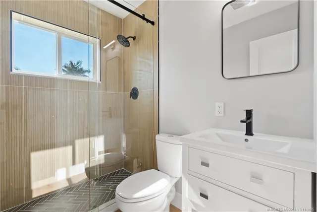 a bathroom with a sink a toilet and shower