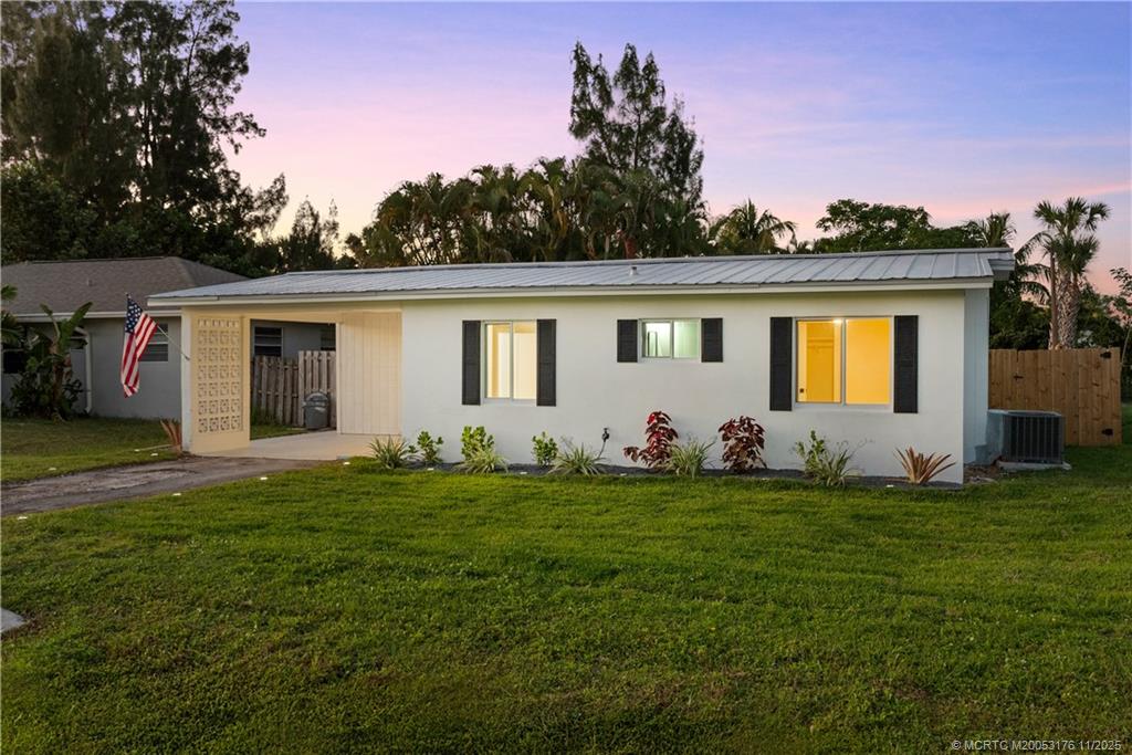 3023 Southeast Banyan Street Stuart, FL 34997 - Photo 6 of 24 a front view of a house with a garden