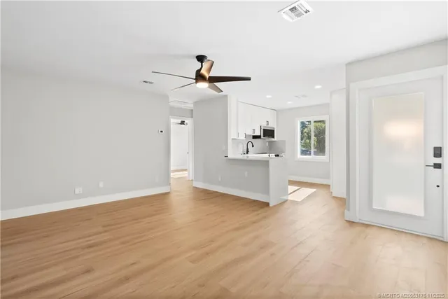 a view of a kitchen with wooden floor and a ceiling fan