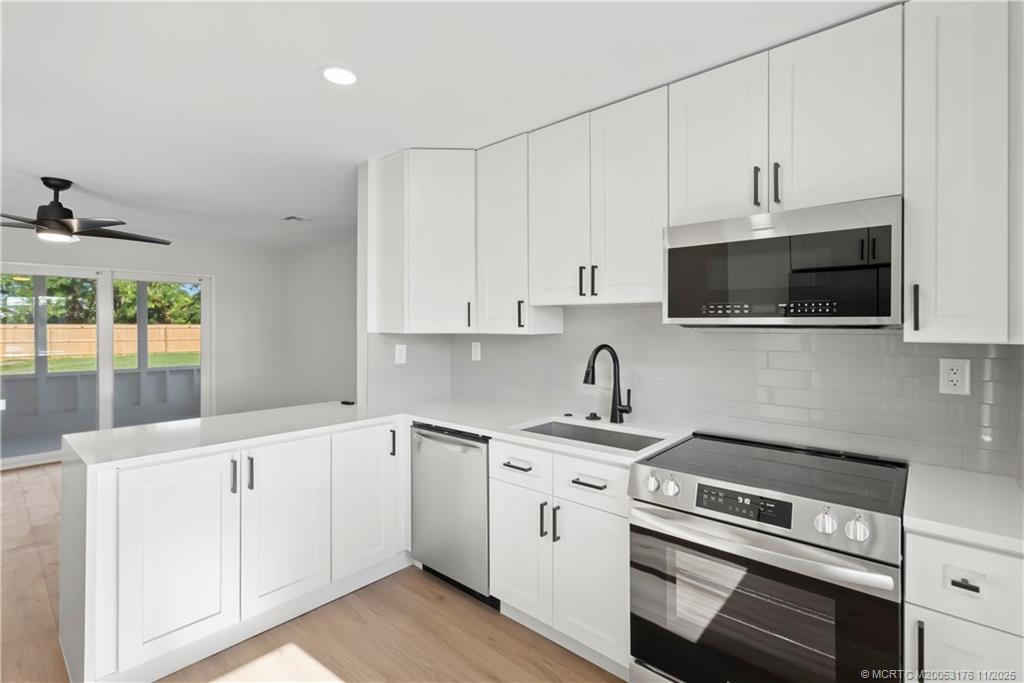 3023 Southeast Banyan Street Stuart, FL 34997 - Photo 9 of 24 a kitchen with appliances a sink and cabinets