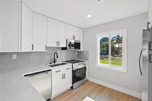 a kitchen with stainless steel appliances granite countertop a stove a sink and a microwave