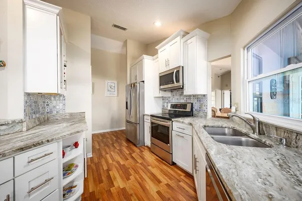 a kitchen with a sink stove top oven and refrigerator