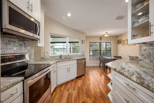 a kitchen with stainless steel appliances granite countertop wooden cabinets stove and sink
