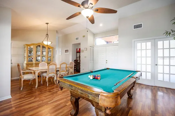 a room with pool table and windows