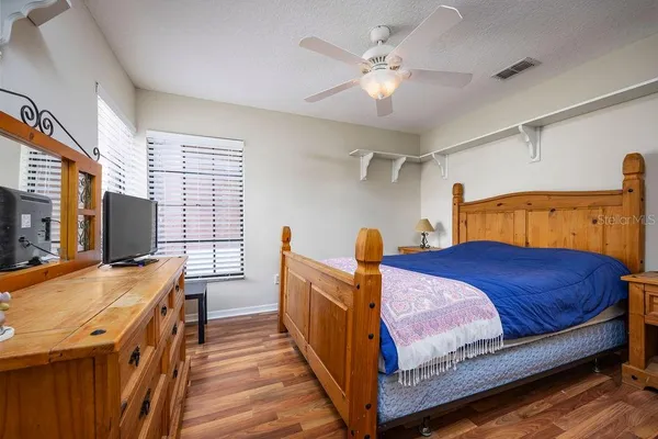 a bedroom with a bed and a flat tv screen on the dresser