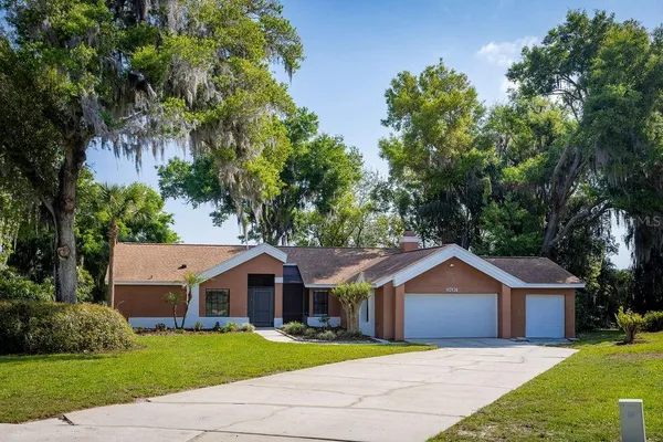 a front view of a house with a garden and trees