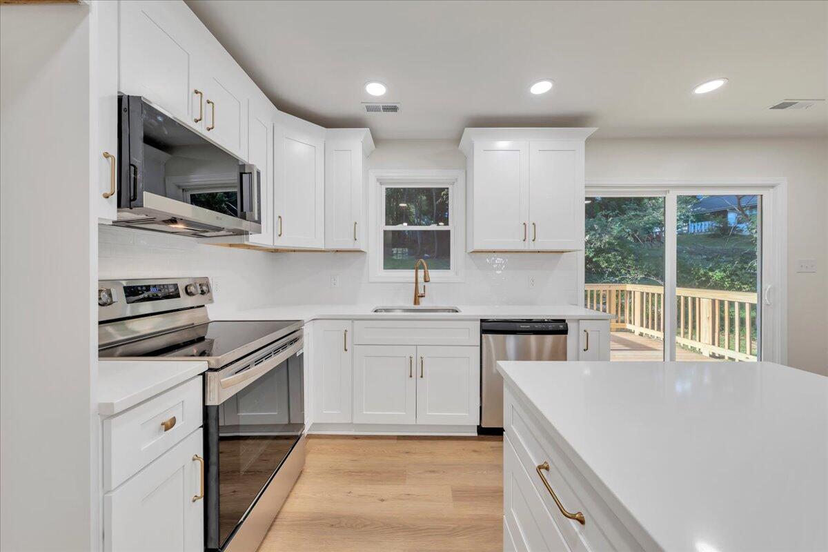 3713 Pinevale Road Roanoke, VA 24018 - Photo 17 of 46 a kitchen with stainless steel appliances granite countertop a stove top oven a sink a microwave and a refrigerator