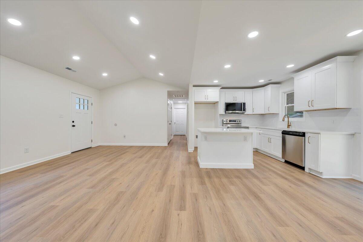 3713 Pinevale Road Roanoke, VA 24018 - Photo 8 of 46 a large kitchen with stainless steel appliances kitchen island a sink dishwasher a refrigerator and white cabinets with wooden floor