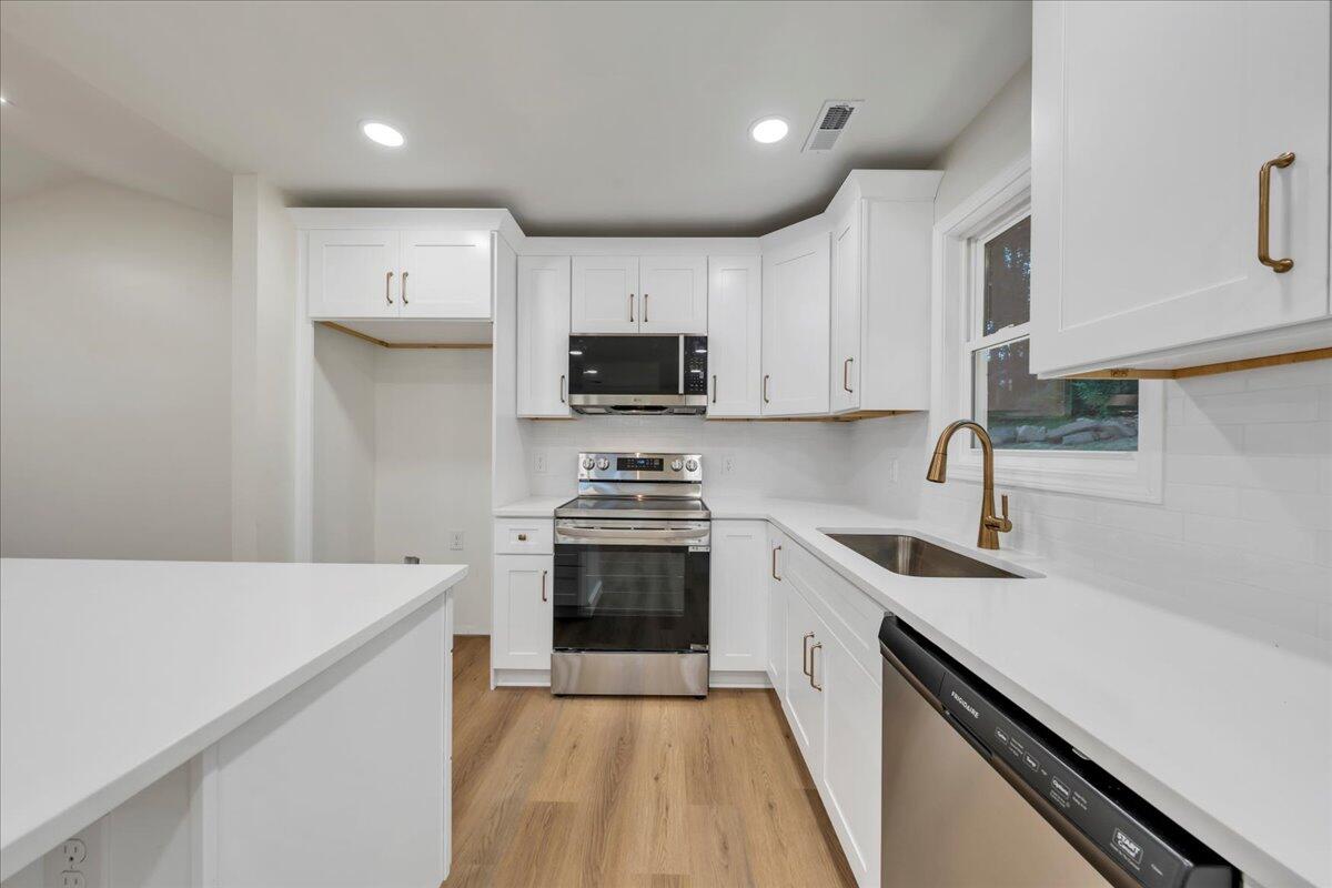 3713 Pinevale Road Roanoke, VA 24018 - Photo 10 of 46 a kitchen with a sink a stove top oven and white cabinets