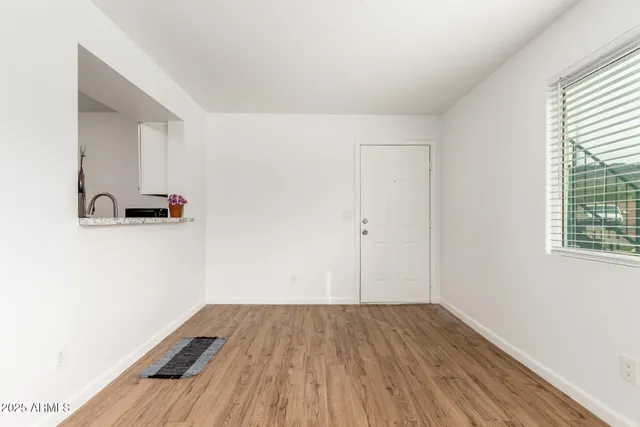 a view of a room with wooden floor and a window