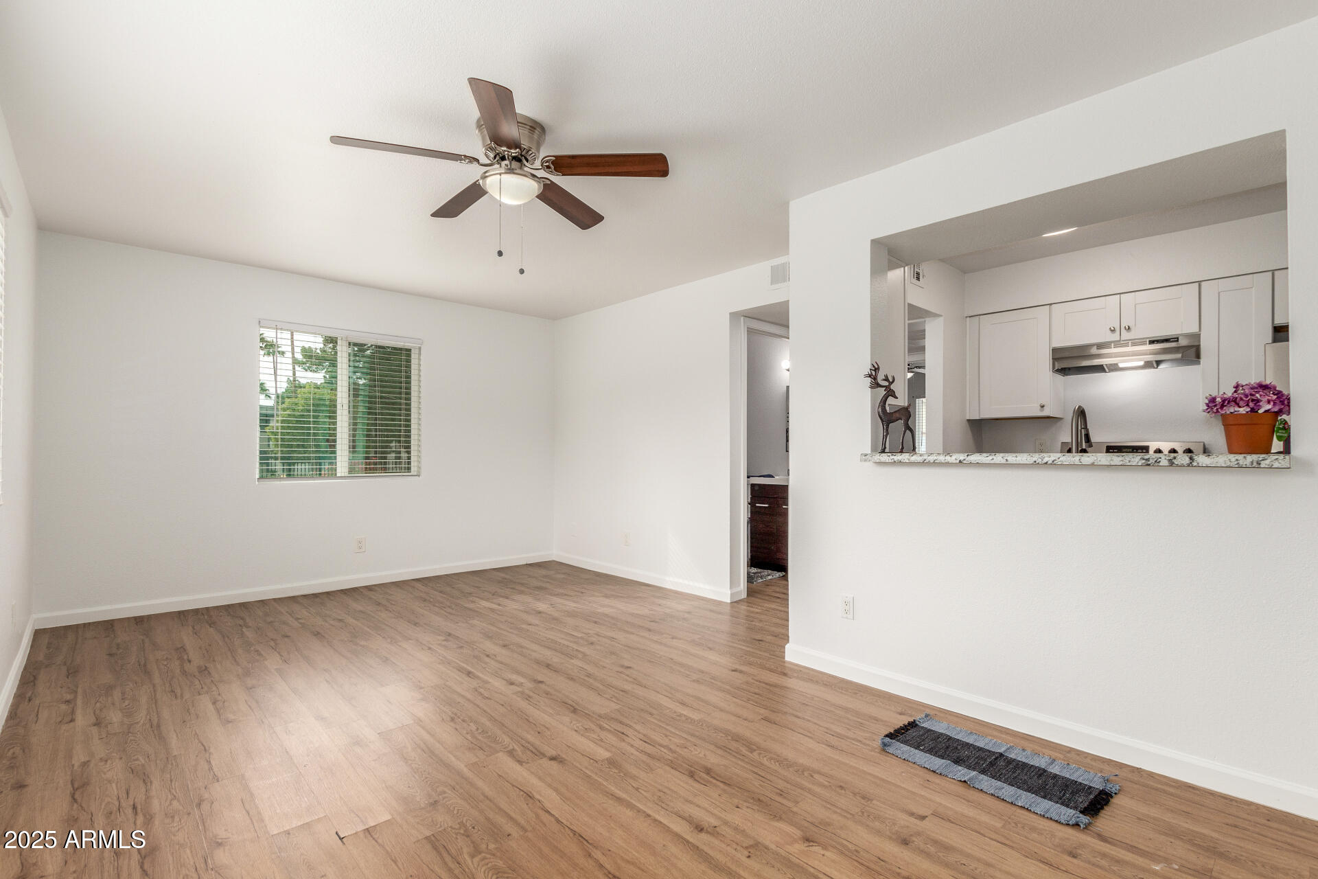 1346 East Mountain View Road, Unit 207 Phoenix, AZ 85020 - Photo 15 of 29 a view of a room with wooden floor and a ceiling fan