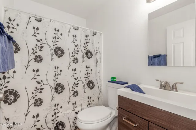 a bathroom with a granite countertop toilet a sink and a toilet
