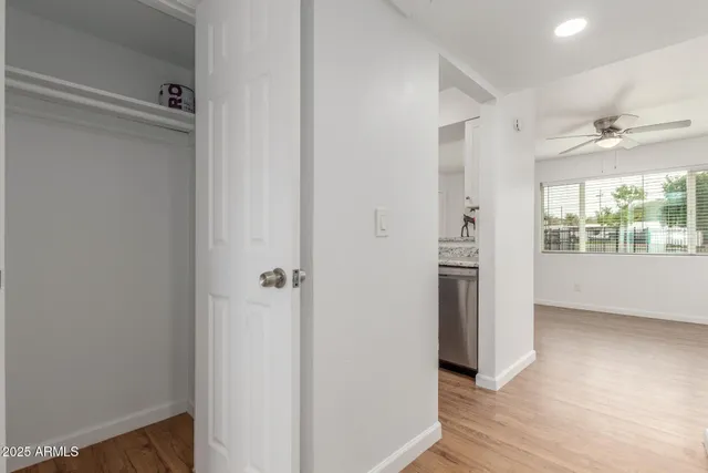 a view of hallway with a large window and wooden floor