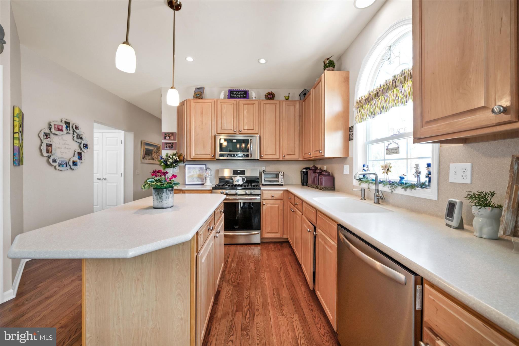 7 Pierson's Ridge Hockessin, DE 19707 - Photo 13 of 59 a kitchen with kitchen island a refrigerator a stove a sink dishwasher and white cabinets with wooden floor