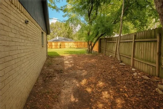 a view of a yard with wooden fence