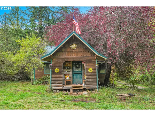 a view of a small house with yard and a tree