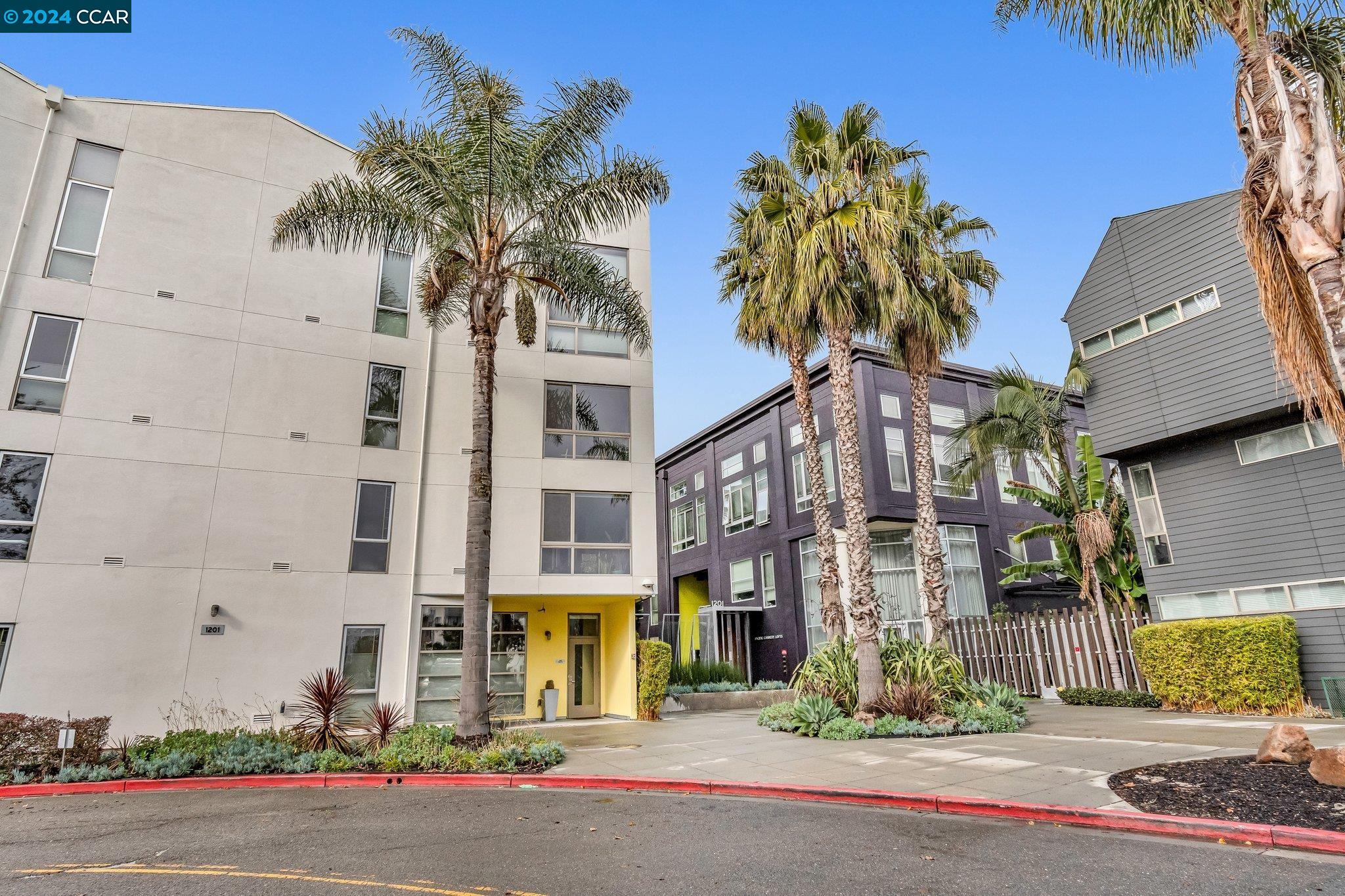 a front view of a multi story residential apartment building with yard and sign board