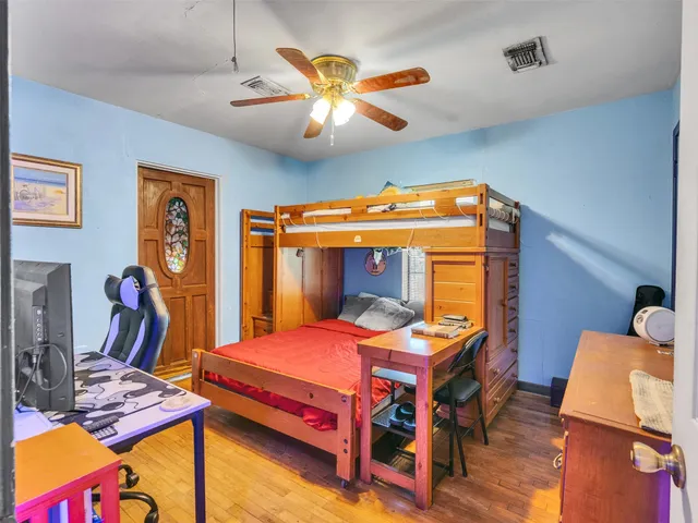 a bedroom with a bed and wooden floor