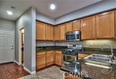 a kitchen with stainless steel appliances granite countertop a stove a sink and a microwave