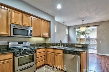 a kitchen with stainless steel appliances granite countertop a stove a sink and a microwave
