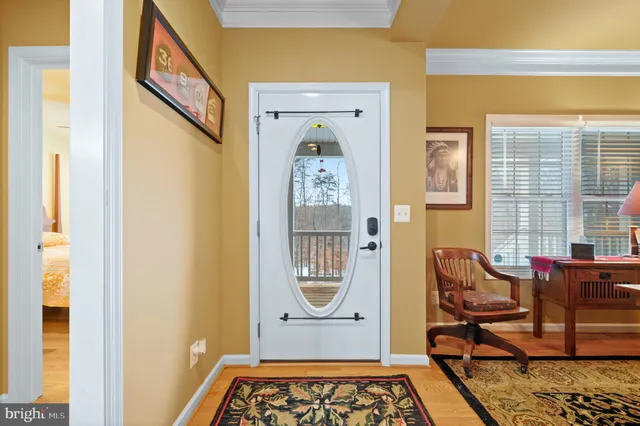 a living room with furniture kitchen view and a wooden floor