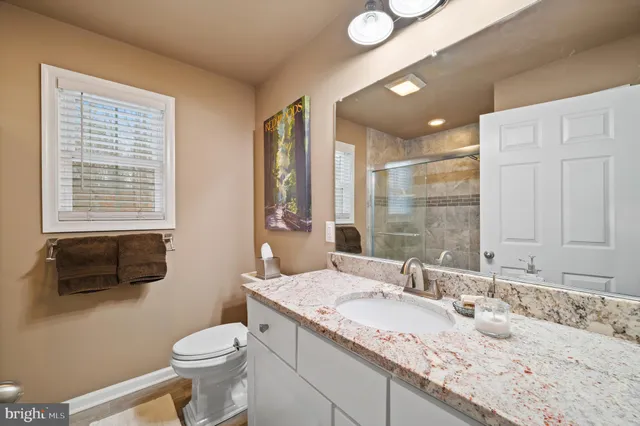 a bathroom with a sink mirror vanity and toilet