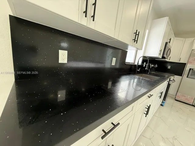 a large white kitchen with a large window