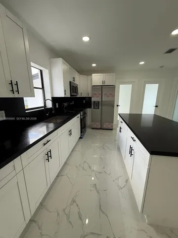 a kitchen with granite countertop a stove and a sink