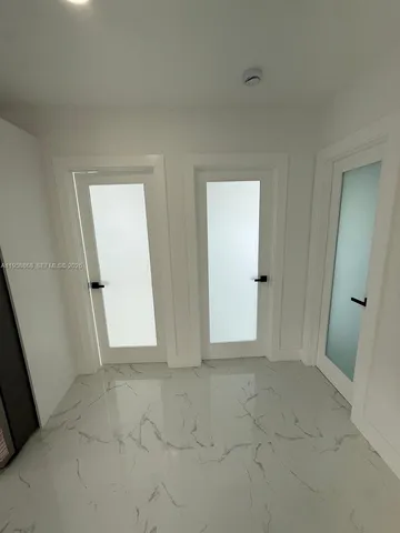 an empty room with windows and ceiling fan